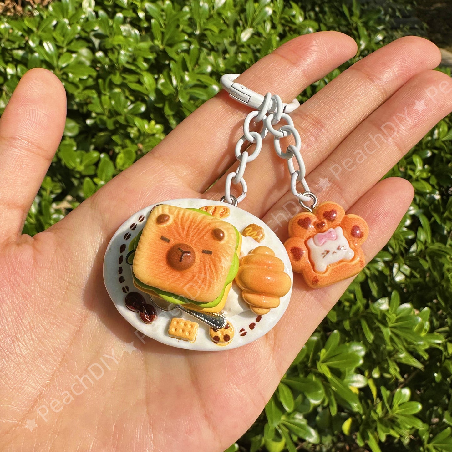 Llavero de arcilla polimérica en miniatura con forma de capibara y sándwich