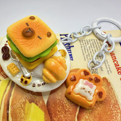Llavero de arcilla polimérica en miniatura con forma de capibara y sándwich
